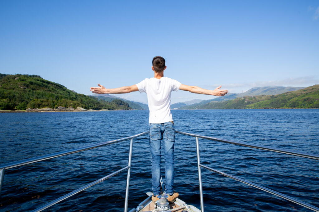 person standing on the front of a boat